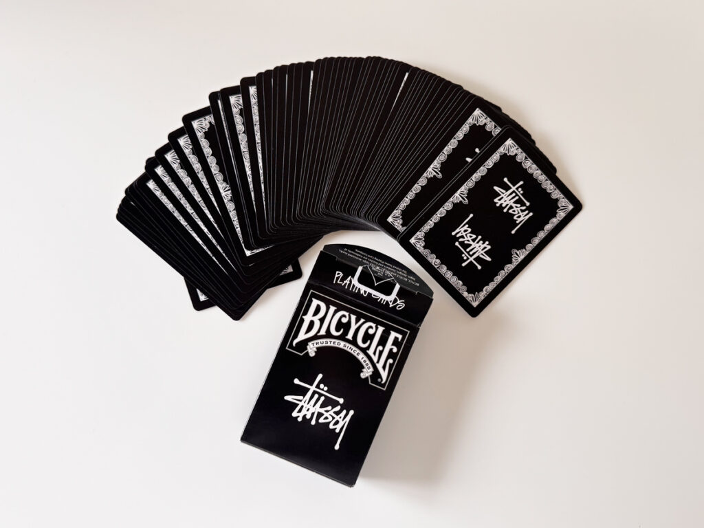 箱とデック、広げたカードのスプレッド。背面枠の連続性が美しい