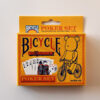 BICYCLE × BE@RBRICKのポーカーセット外箱（黄橙のパッケージとベアの自転車イラスト）