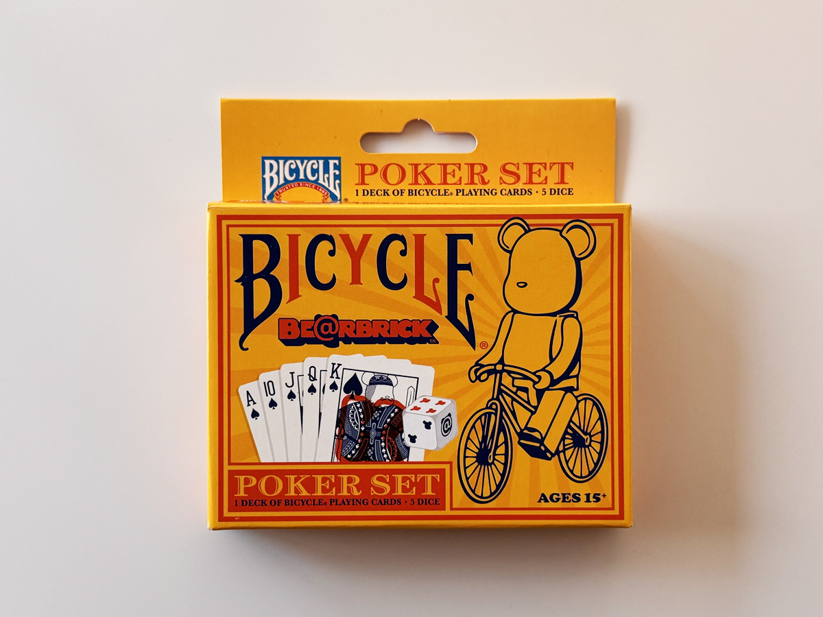 BICYCLE × BE@RBRICKのポーカーセット外箱（黄橙のパッケージとベアの自転車イラスト）