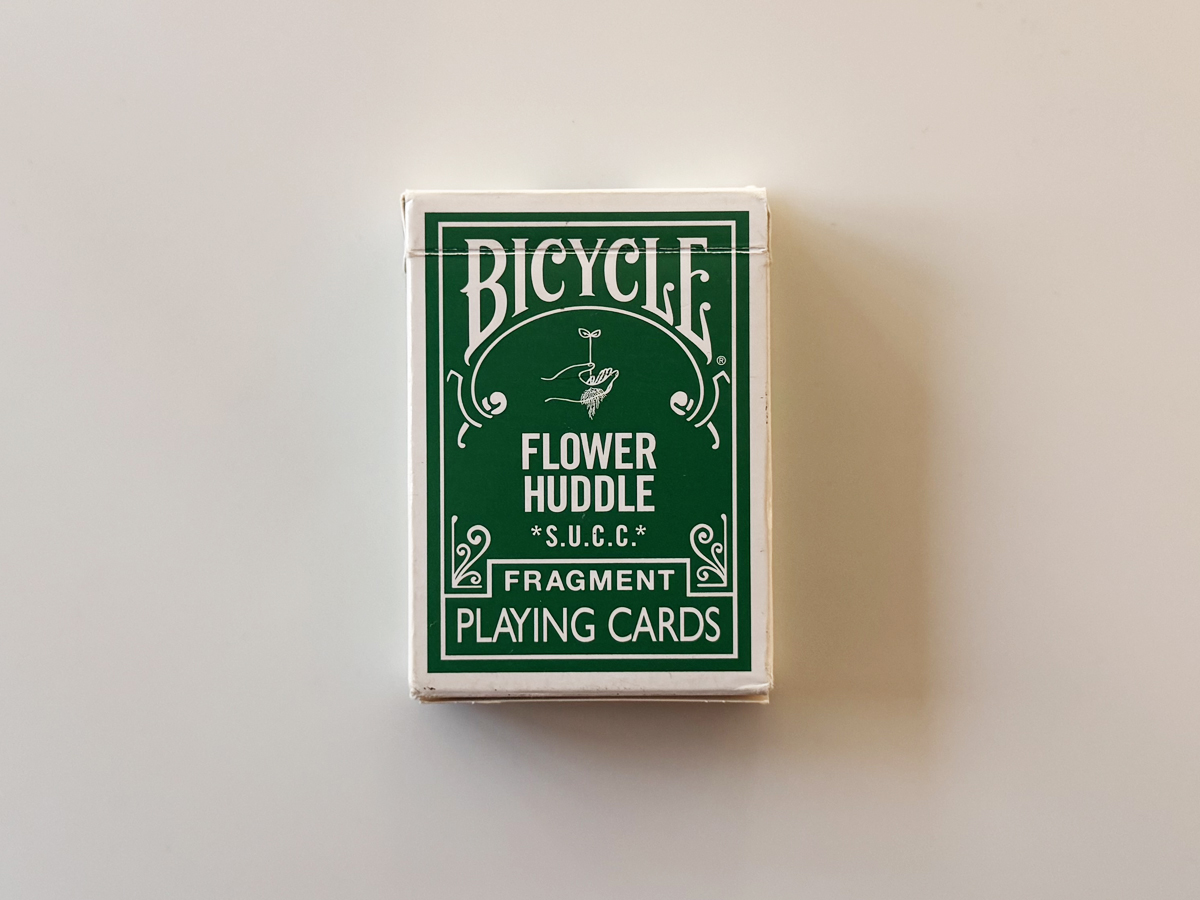 BICYCLE × fragment “FLOWER HUDDLE” グリーンのタックケース正面。ロゴとモデル名が映る実機写真。