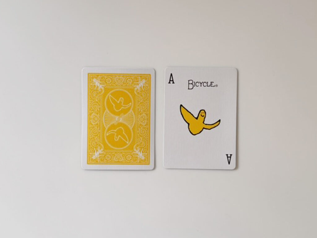 黄色い鳥が描かれたAカードとトランプカード裏面の比較写真